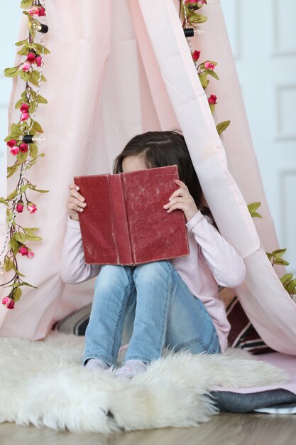 Cute girl reading a book around cute decoration