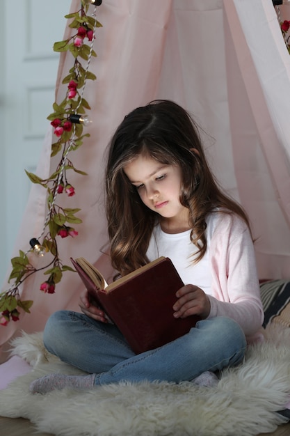 Cute girl reading a book around cute decoration