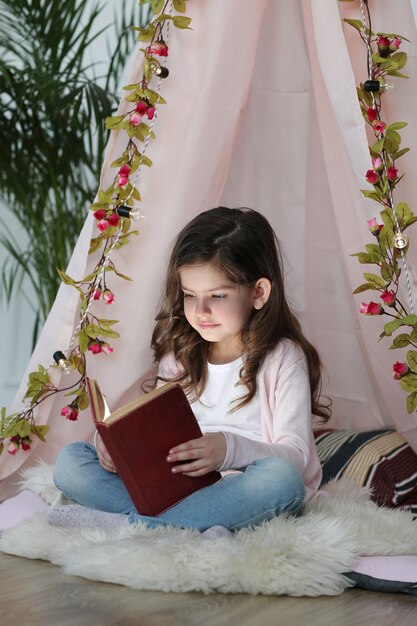 Милая девушка читает книгу вокруг милого украшения