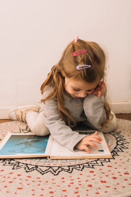 Free photo cute girl reading on carpet