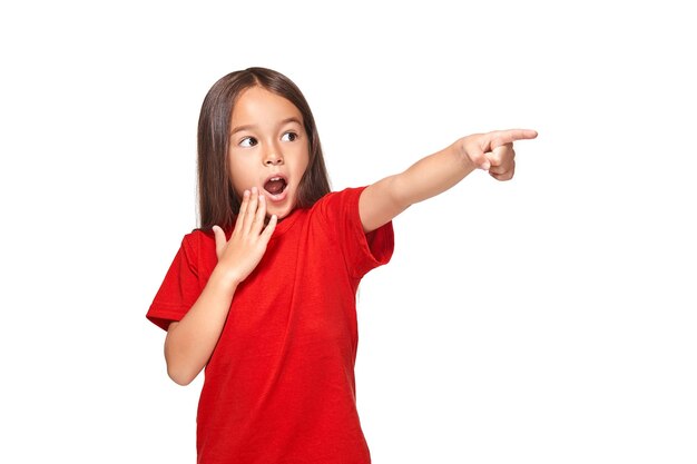 Cute girl in red t-shirt shows isolated on white background in red t-shirt