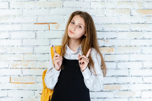 Free photo cute girl in school uniform point fingers up