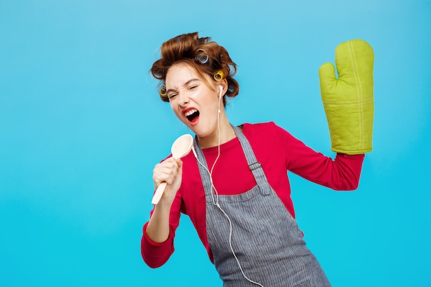 Foto gratuita la ragazza sveglia canta le canzoni in cucchiaio che ascolta la musica