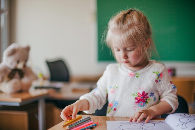 Free photo cute girl sitting and drawing