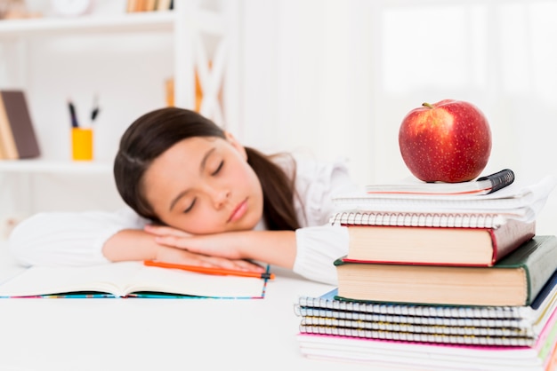 Foto gratuita ragazza carina che dorme vicino a libri