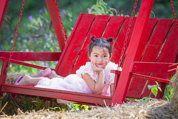 Cute girl smiling happily wearing a beautiful pink dress.