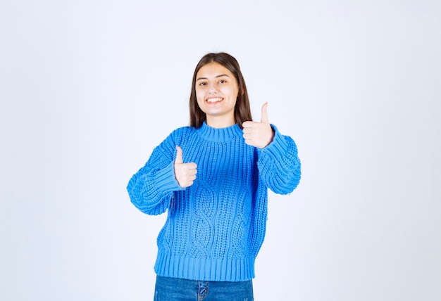 cute girl standing and giving thumbs up on white.