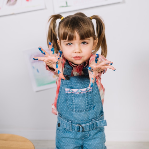 Cute girl standing with painted fingers