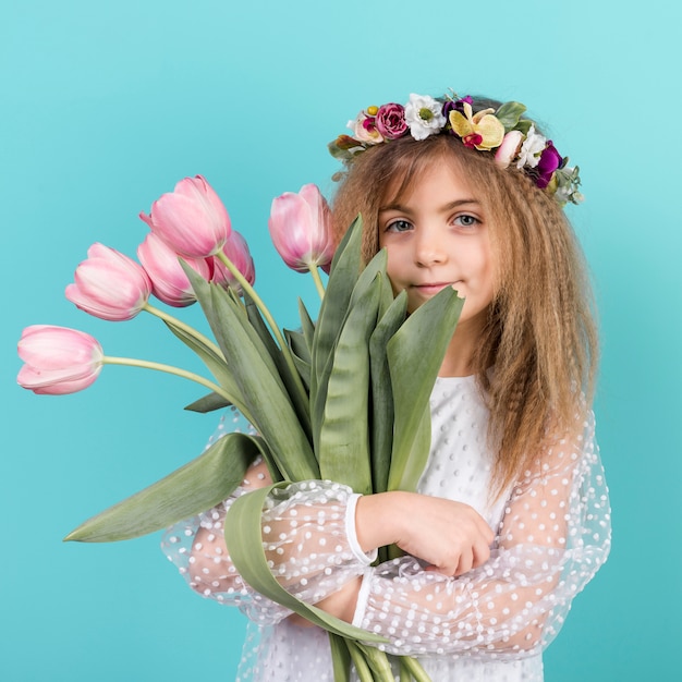 Free photo cute girl standing with pink tulip flowers