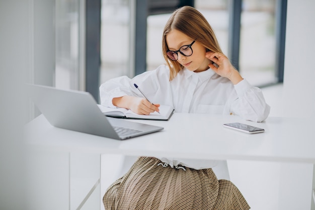 Ragazza carina che studia sul computer a casa