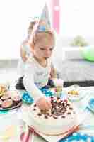 Free photo cute girl taking out candles from cake