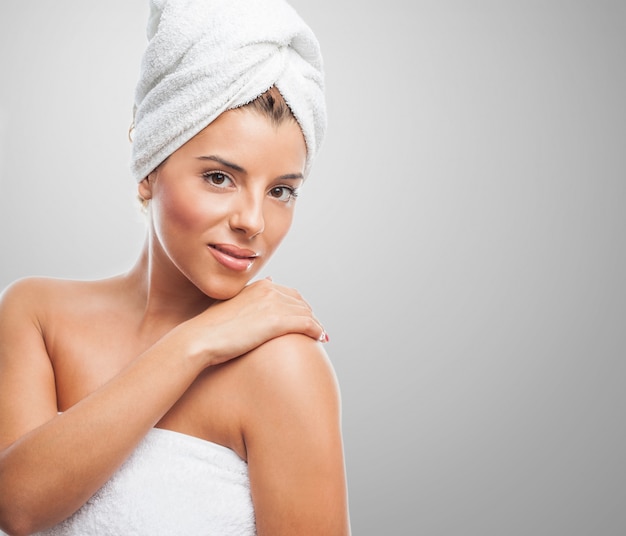 Cute girl in towel against grey background.