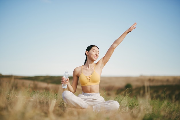 Cute girl training on blue sky in a field