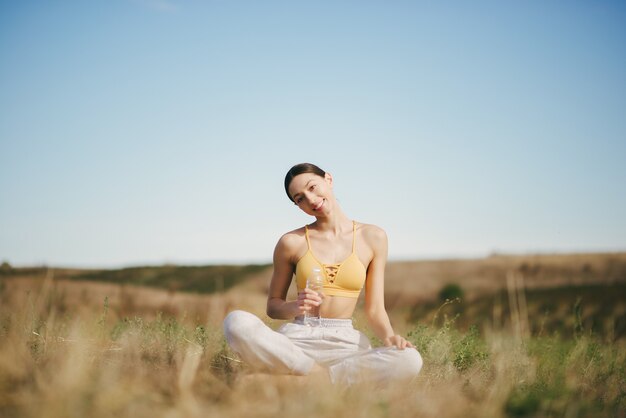 Cute girl training on blue sky in a field