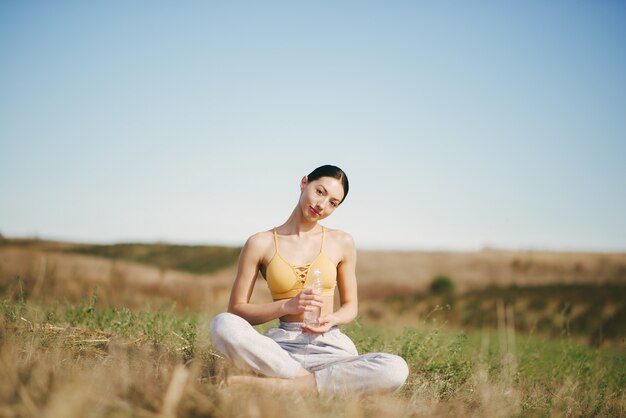 Cute girl training on blue sky in a field