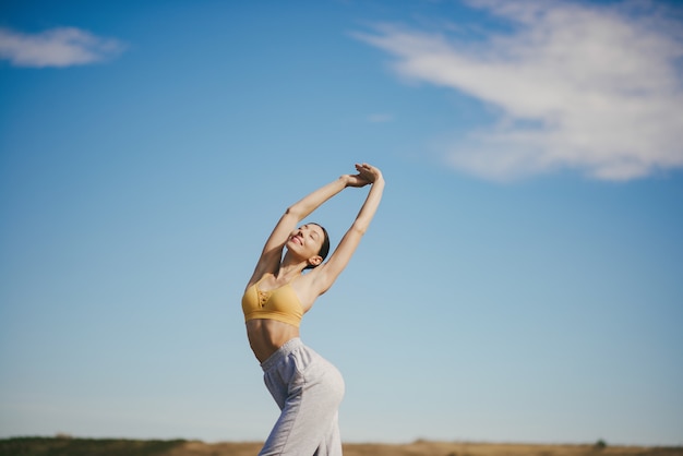 Cute girl training on blue sky