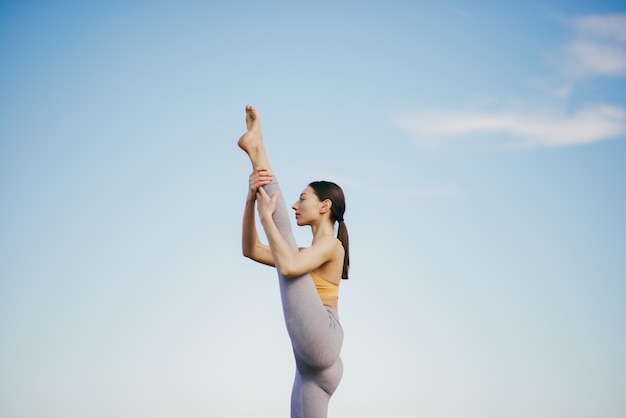 Cute girl training on blue sky