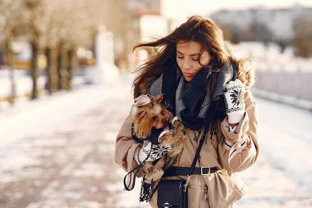 Милая девушка гуляет в зимнем парке со своей собакой