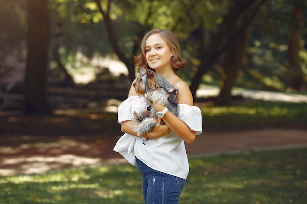 小さな犬と遊ぶ白いブラウスでかわいい女の子