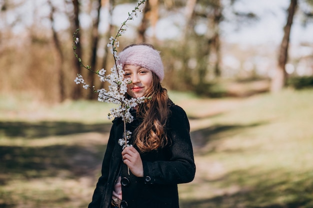 Cute girl with blooming brench in park