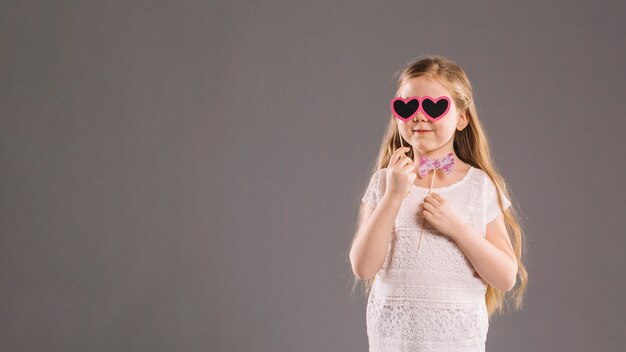 Free photo cute girl with bow tie and heart glasses