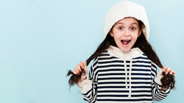 Cute girl with hoodie playing with hair