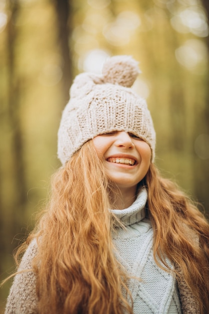 Cute girl with long red hair in autumnal forest