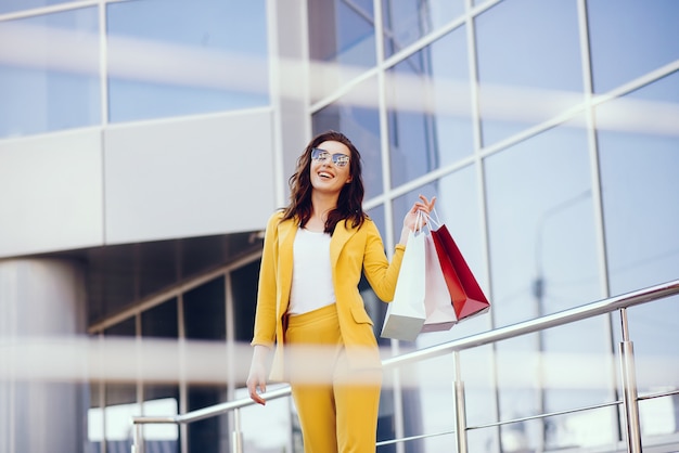 Foto gratuita ragazza carina con shopping bag in una città