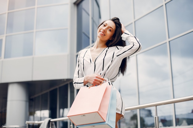 Foto gratuita ragazza carina con shopping bag in una città