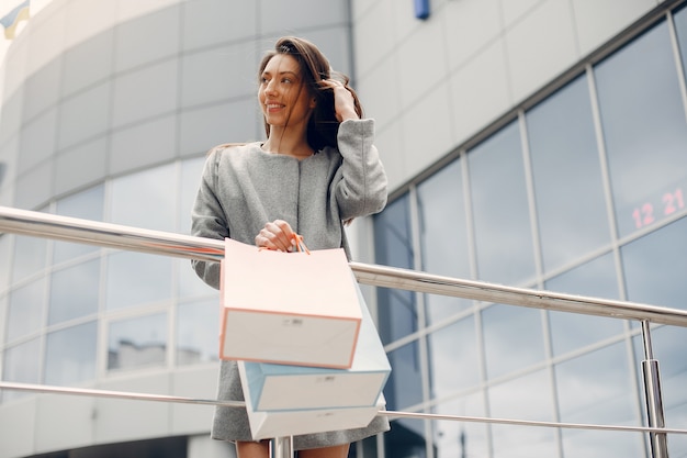 Foto gratuita ragazza carina con shopping bag in una città