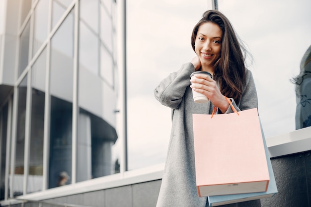 Ragazza carina con shopping bag in una città