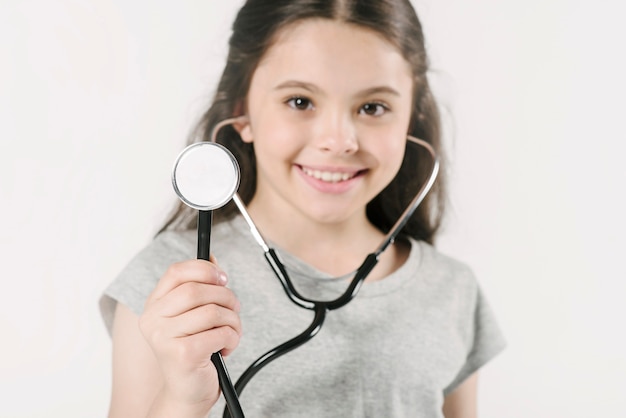 Cute girl with stethoscope in studio