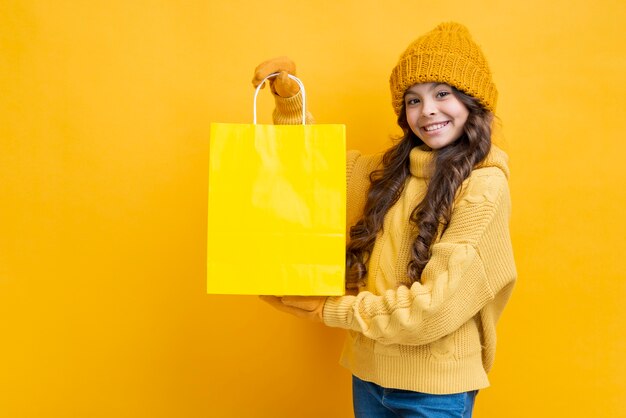 Cute girl with a yellow shopping bag