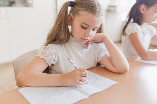 Cute girl writing in notebook