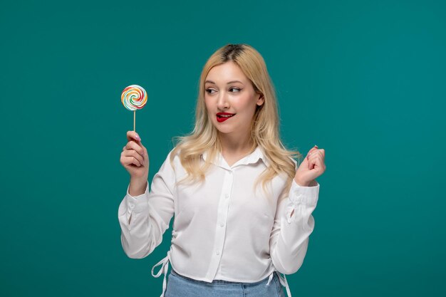 Cute girl young adorable pretty girl in a white neat shirt biting lips holding a sweet lollipop