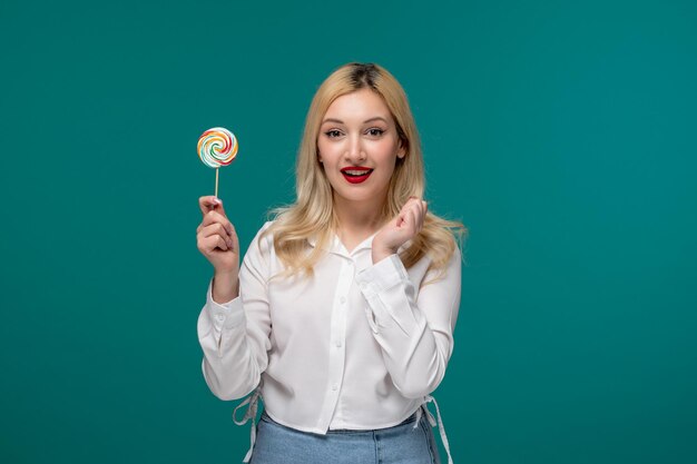 Cute girl young adorable pretty girl in a white neat shirt excited with a pink lollipop