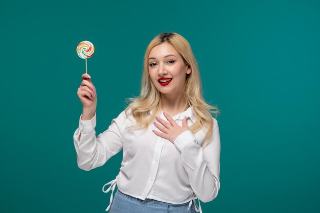 가슴과 롤리팝을 들고 흰색 깔끔한 셔츠에 귀여운 소녀 젊은 사랑스러운 예쁜 소녀