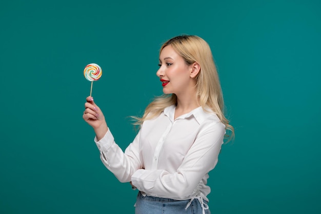 Cute girl young adorable pretty girl in a white neat shirt looking at lollipop and happy