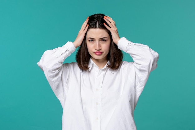 Cute girl young pretty adorable brunette girl in white shirt holding head very upset