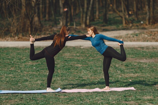 Cute girls doing yoga in a summer park