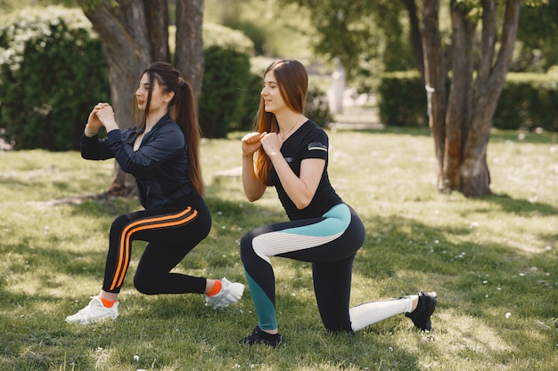 Foto gratuita ragazze sveglie che fanno yoga in un parco di estate