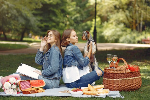 cute girls in a park playing with little dog