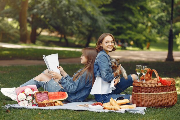 cute girls in a park playing with little dog