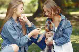 Foto gratuita ragazze carine in un parco giocando con cagnolino