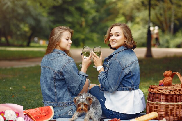 cute girls in a park playing with little dog