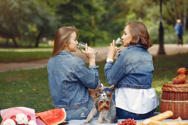 Cute girls in a park playing with little dog