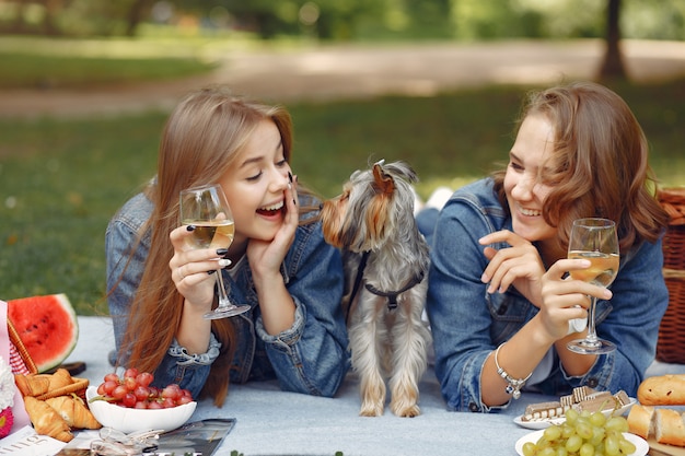 Free photo cute girls in a park playing with little dog