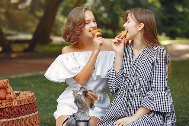 cute girls in a park playing with little dog