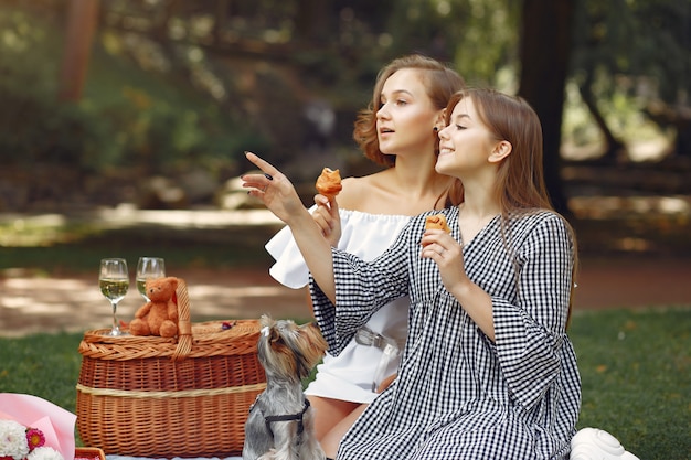 cute girls in a park playing with little dog