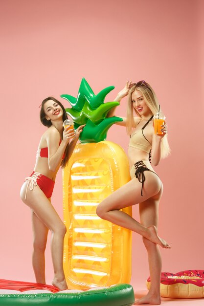 Cute girls in swimsuits posing at studio. Summer portrait caucasian teenagers